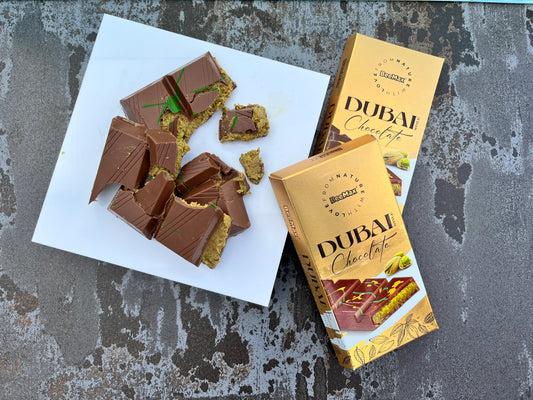 Dubai chocolate bars with packaging on a textured surface